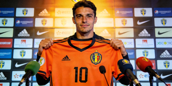 足球转会市场新闻报道配图 - 一名球员手持新俱乐部球衣